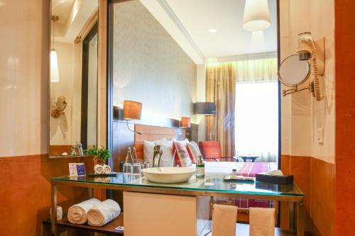 a bathroom with a counter with a bowl on it at Balaji Sarovar Premiere in Solapur