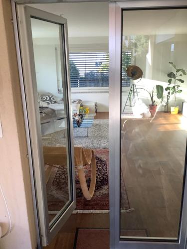 a sliding glass door with a view of a living room at Chambre spacieuse, lumineuse et reposante in Oetwil an der Limmat