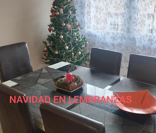a table with a christmas tree in a room at Lembranzas in Padrón