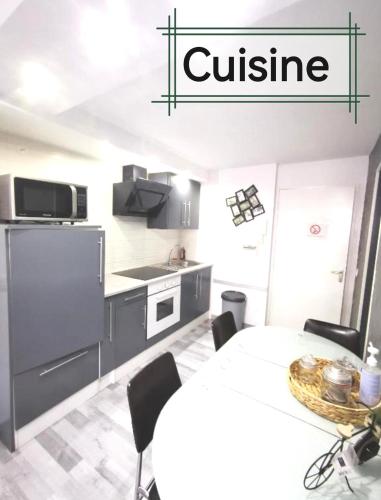 une cuisine avec une table et des chaises ainsi qu'un panneau indiquant la cuisine dans l'établissement Rodez centre ville, Parking gratuit, Petit déjeuner, à Rodez