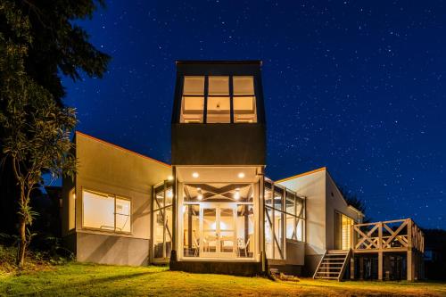 a house with a tower at night at Sunlit Villa Izu -星降る陽だまり森の宿- in Ito