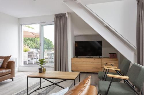 a living room with a couch and a tv at Appartement Sneekermeer in Sneek