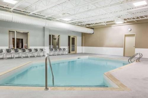 a large swimming pool in a room with chairs at Super 8 by Wyndham Peterborough in Peterborough