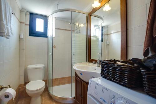 een badkamer met een toilet, een douche en een wastafel bij Luxury 2br apartment 50m from beach in Pefkochori