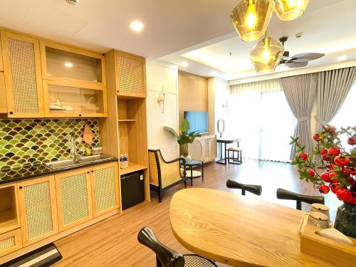 a kitchen and dining room with a wooden table at FLC Sea Tower Quy Nhon SeaView Condotel in Quy Nhon