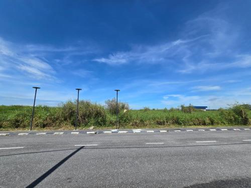 an empty road with street lights on the side of the road at Humaira Homestay Teluk Intan in Teluk Intan