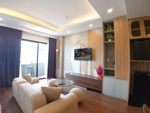 a living room with a couch and a tv at FLC Sea Tower Quy Nhon SeaView Condotel in Quy Nhon