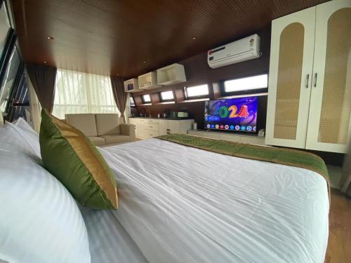 a large white bed in a room with a tv at Amara Kosha Misty Hills - Brahma in Nandi