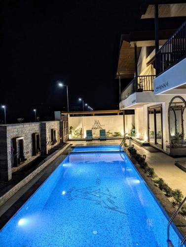 a swimming pool in front of a building at night at Amara Kosha Misty Hills - Brahma in Nandi