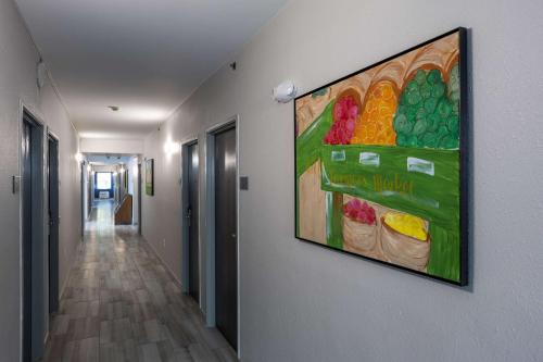 a painting of fruit on a wall in a hallway at Rodeway Inn & Suites near Outlet Mall - Asheville in Asheville
