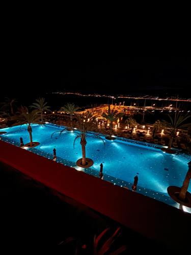 een groot zwembad met 's nachts mensen erin bij Palm Beach front de mer in Cannes