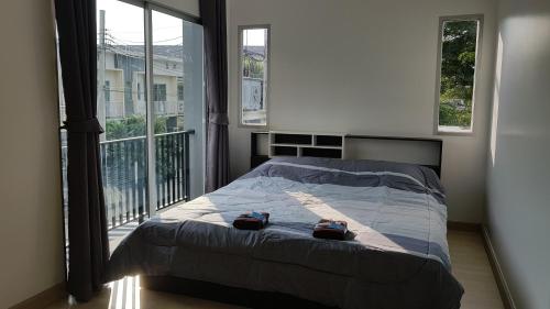 a bedroom with a bed with two bags on it at Nido house in Ban Bang Phang