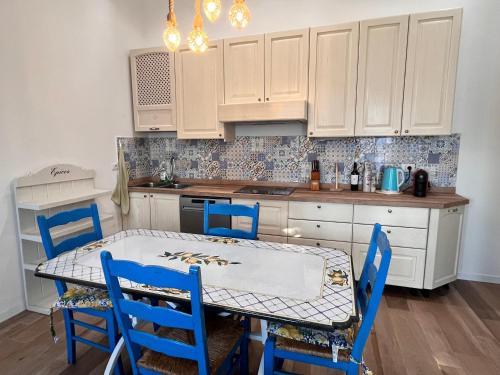 una cocina con mesa y sillas azules. en Corte Basiglio, en Basiglio