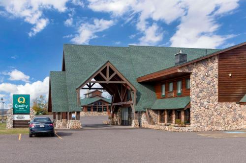 a car parked in front of a building with a green roof at Quality Inn Ashland - Lake Superior in Ashland
