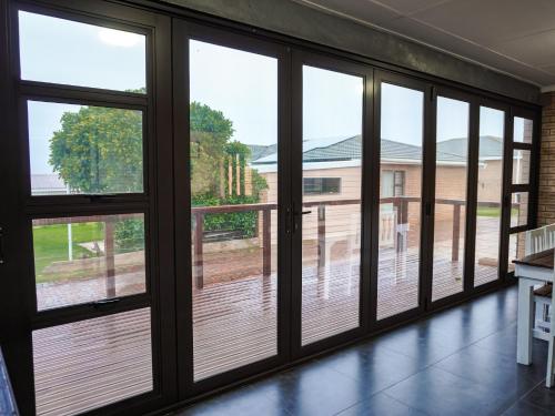 a room with sliding glass doors looking out onto a deck at Barefoot Dreams 13A in Jeffreys Bay