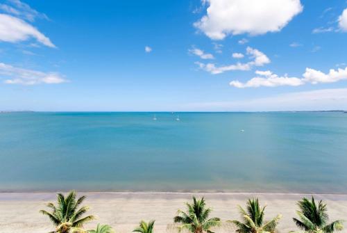 a view of a beach with palm trees and the ocean at Ramada Suites by Wyndham Wailoaloa Beach Fiji in Nadi