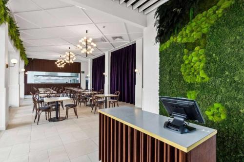 a restaurant with a tv on a counter with a green wall at Ramada by Wyndham, Hamilton City Center in Hamilton