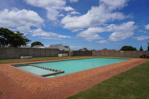 a swimming pool in a yard with a brick at Barefoot Dreams 13A in Jeffreys Bay