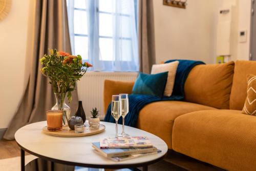 - un salon avec un canapé et une table avec des verres à vin dans l'établissement La Cour du Cygne - By PrestiPlace, à Tours