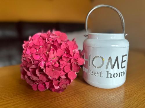 a jar of home sweet home next to a pink flower at Ferienhaus Hentzschel in Kurort Altenberg