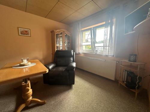 a living room with a chair and a table at Ferienhaus Hentzschel in Kurort Altenberg