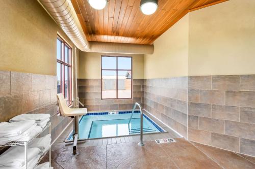a bathroom with a swimming pool with a table and a chair at Comfort Inn & Suites Mountain Iron and Virginia in Mountain Iron