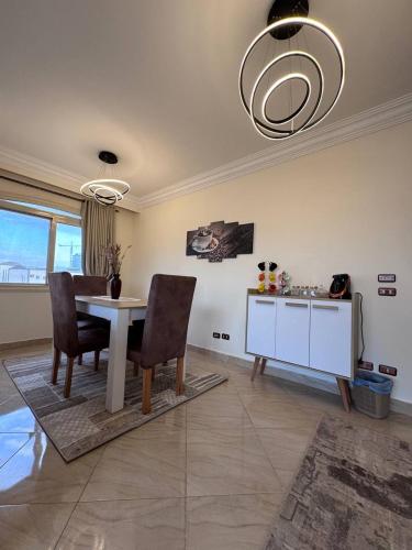a dining room with a table and chairs in a room at شقة بموقع متميز في الشيخ زايد in Sheikh Zayed