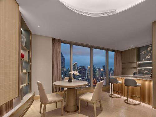 a room with a table and chairs and a large window at Conrad Shanghai in Shanghai