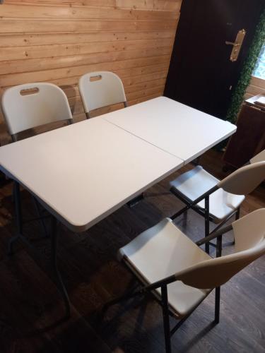 un tavolo bianco e sedie in una stanza di Cabana AFO A Frame a Brăteasca