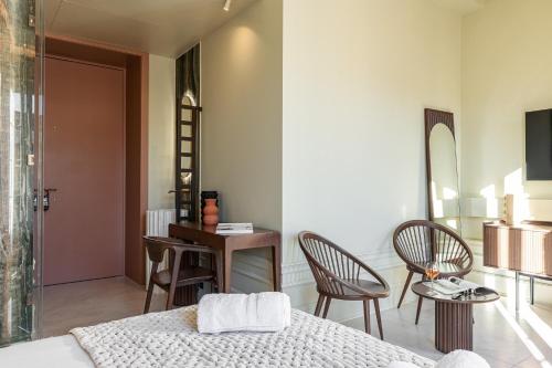 a bedroom with a bed and a table and chairs at Naomi Nice in Nice