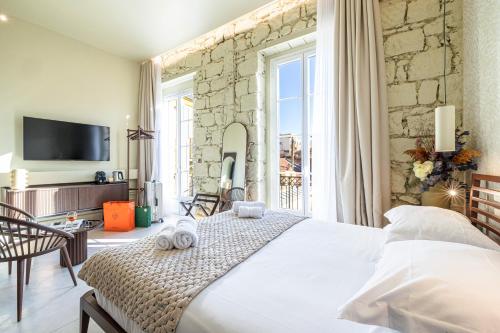 a bedroom with a white bed and a stone wall at Naomi Nice in Nice