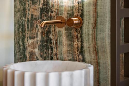 a white vase in front of a wall with a towel at Naomi Nice in Nice