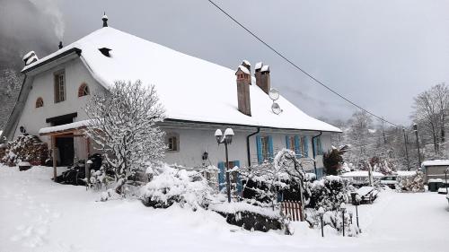 a house with a snow covered roof at Magnifique appartement campagnard avec beaucoup de cachet in Vugelles-La Mothe