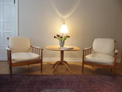 two chairs and a table with a lamp and flowers on it at Hotel Esplanade, BW Signature Collection in Stockholm