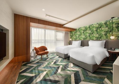 a hotel room with two beds and a television at JAI Château Hotels & Hostels in Tainan