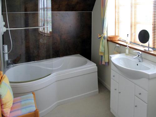 La salle de bains est pourvue d'une baignoire blanche et d'un lavabo. dans l'établissement Westacre Lodge, à Auchterarder