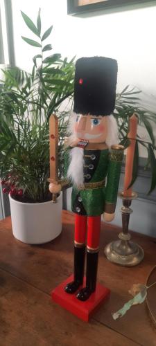 a wooden nutcracker statue on a table next to a plant at La Villa Beausejour in Baives