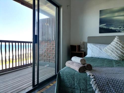 una camera da letto con un letto e asciugamani arrotolati di Mitford Holiday Flats a Morgan's Bay