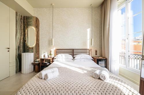 a bedroom with a large bed with towels on it at Naomi Nice in Nice