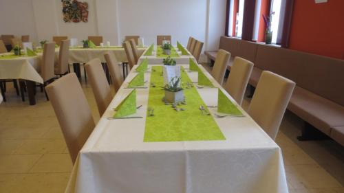 a long table with a white table cloth and chairs at Gasthof zur Sonne in Jettingen-Scheppach