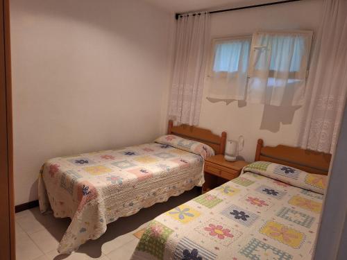 a bedroom with two beds and a window at Apartamento frente a la Playa in Suances