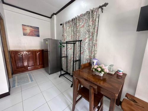 a room with a wooden table and a refrigerator at Room 1 Family Fuego Island Guest House By Fuego Island Private Resorts in San Juan