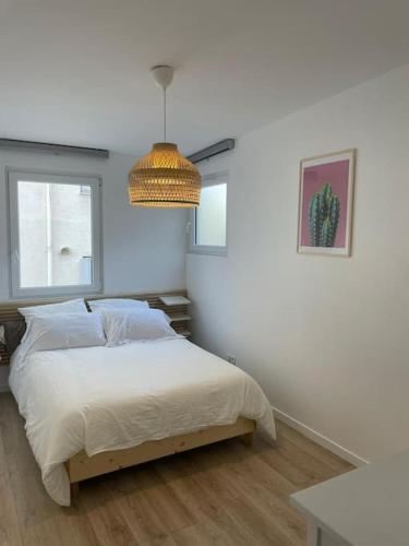 une chambre blanche avec un lit et une fenêtre dans l'établissement 2P Porte de Paris, sortie métro face au bois, à Charenton-le-Pont