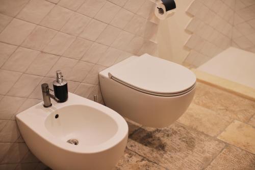 a bathroom with a white toilet and a sink at Chez Liart 1 in Fasano