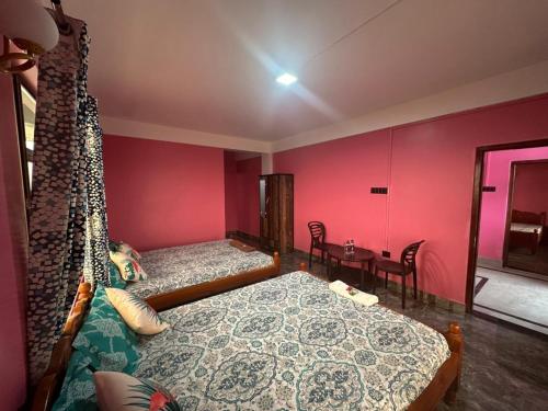 a bedroom with a bed and a table with chairs at Odyssey Stays Nongrim, Cherrapunji in Cherrapunji