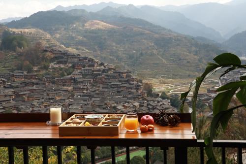 a table with two glasses of juice and a view of a city at Xijiang Sanchunli Zhong Panorama Meisu in Xijiang