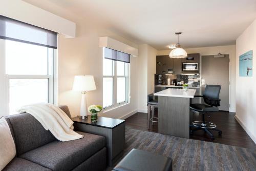 a living room with a couch and a desk and a kitchen at Hyatt House Charleston - Historic District in Charleston