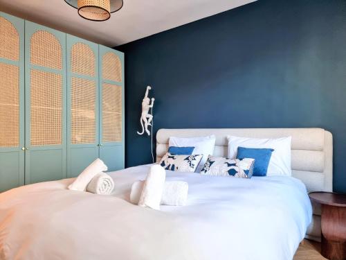 une chambre avec un grand lit blanc avec des murs bleus dans l'établissement Luxury Flat with balcony near Arc de Triomphe, à Paris
