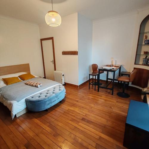 a bedroom with a bed and a table and a desk at Haven Douce in Champigny-sur-Marne