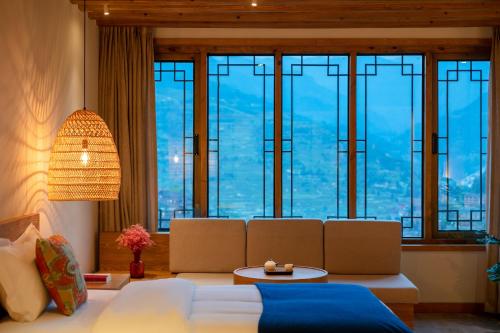 a bedroom with a large bed and a large window at Xijiang Sanchunli Zhong Panorama Meisu in Xijiang